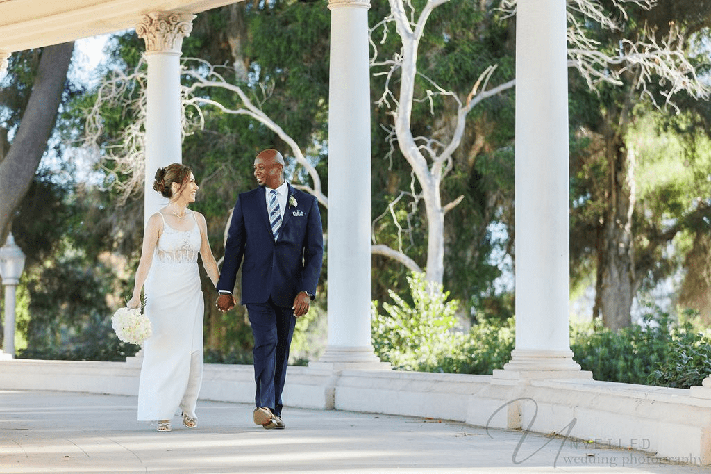 Couple walking by white pillars for San Diego Courthouse Wedding Photography outdoors.