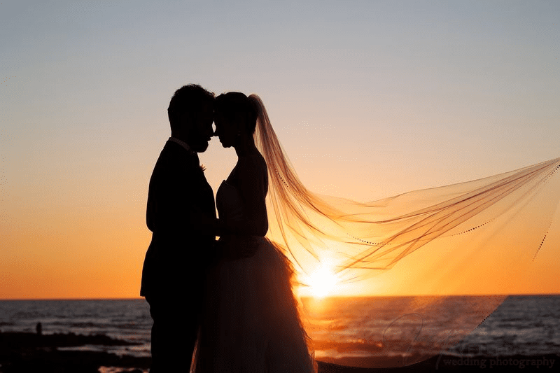 A Second wedding Photographer captures a sunset silhouette of a bride and groom.