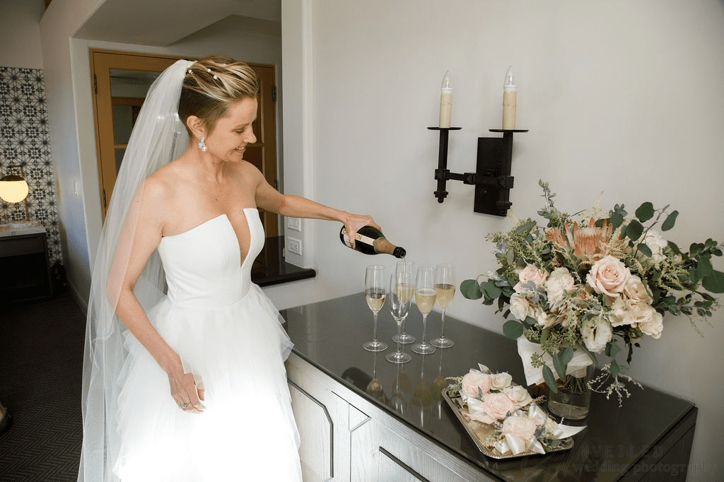 A bride pouring champagne is captured here by our Second wedding Photographer.