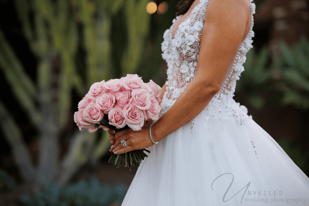 A bride's pink rose bouquet and diamond rings, captured by a La Jolla Wedding Photographer.