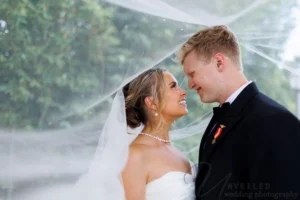 Bride and groom sharing a romantic moment under wedding veil outdoors in Balboa Park wedding photography