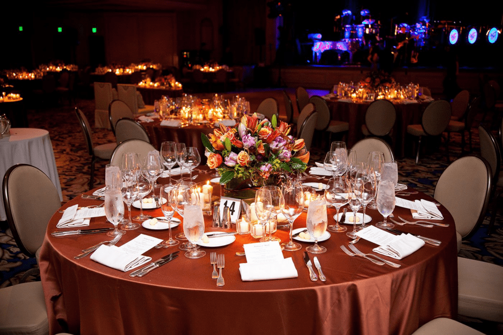 An elegant banquet table setting with a floral centerpiece at a formal reception.