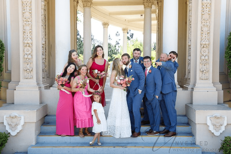 A bride and groom sharing a romantic embrace outdoors on a wooden deck.