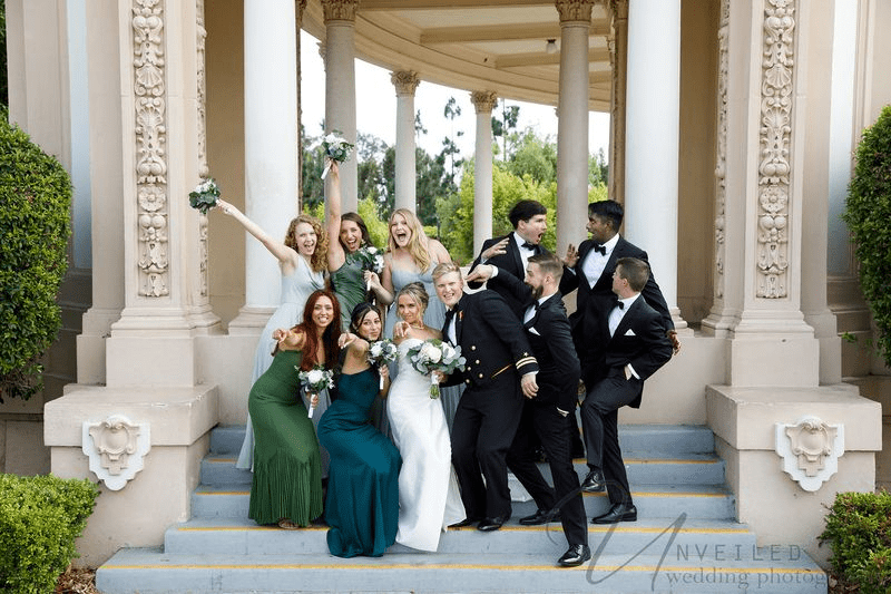 Romantic wedding portrait of couple under veil at outdoor garden venue