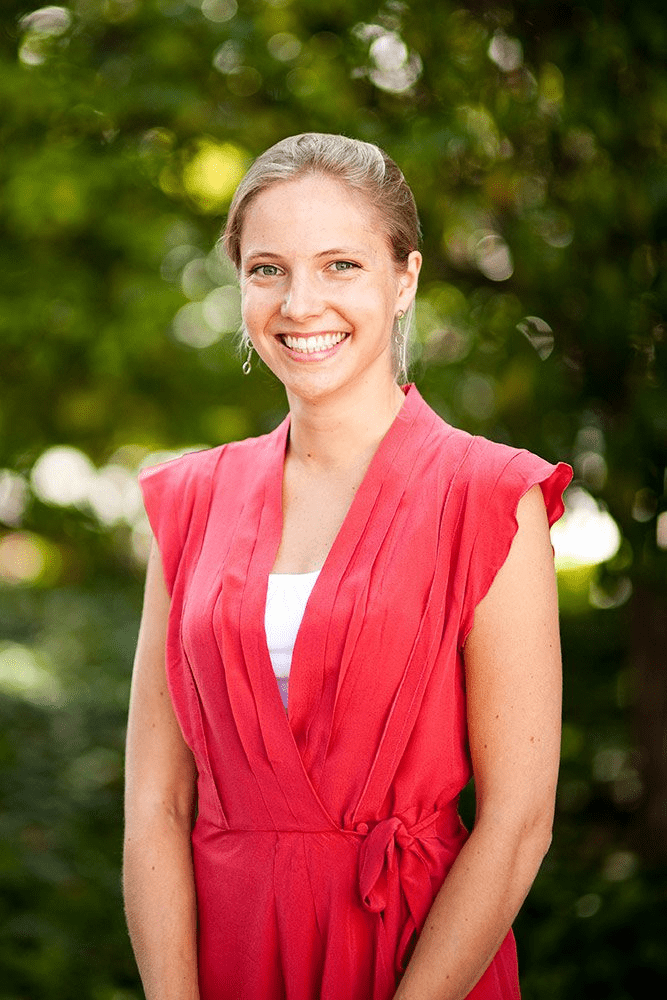 Professional San Diego corporate headshots featuring a confident businesswoman in formal attire, taken outdoors with soft natural light and blurred background.