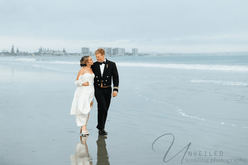 Elegant bride and groom under veil at scenic outdoor wedding location