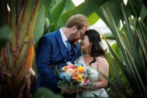 A joyful bride and groom sharing a candid laugh outdoors, beautifully demonstrating how to pose for wedding photos naturally without feeling awkward.