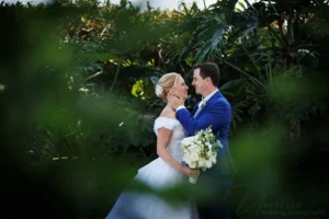 Bride and groom portrait framed by lush foliage for Wedding Photography Contract.