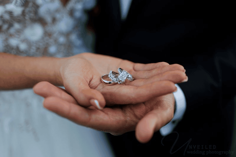 Estancia La Jolla wedding photography close up of rings in the couple's hands.
