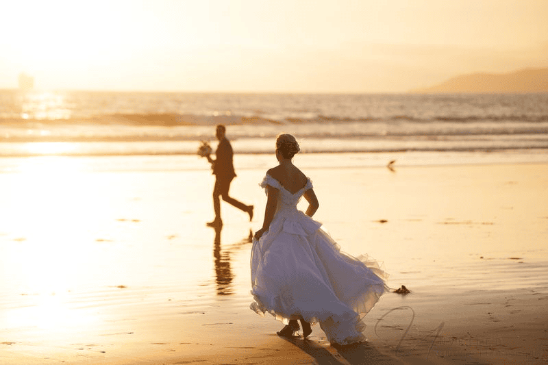 Bride and groom walking on beach at sunset for a Wedding Photography Shot List.