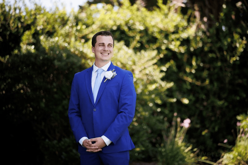 Handsome groom in blue suit posing for Wedding Photography Contract.