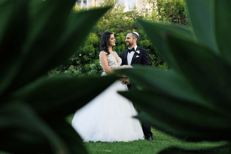 Estancia La Jolla wedding photography of a bride and groom framed by leaves.