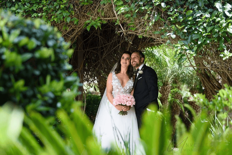 Estancia La Jolla wedding photography featuring a bride and groom under a green canopy.