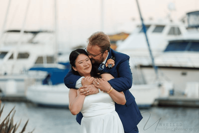 Couple holding each other closely during a pose for wedding photos session