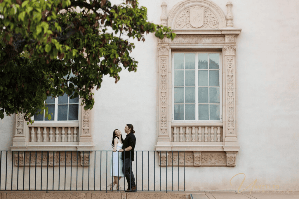 engagement photographer cost San Diego: Couple posing by an elegant ornate building.