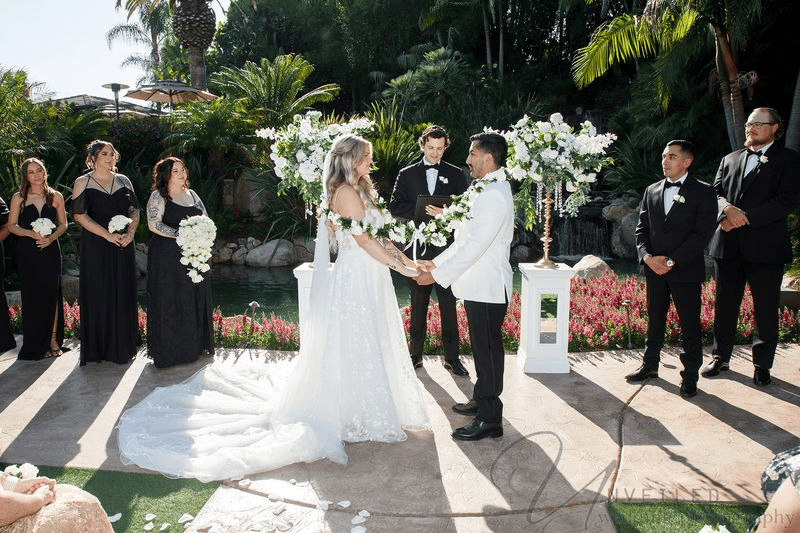 Wedding ceremony holding hands outdoors at Grand Tradition Fallbrook.