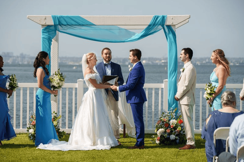 Bride and groom exchanging vows under arch during intimate wedding in San Diego.