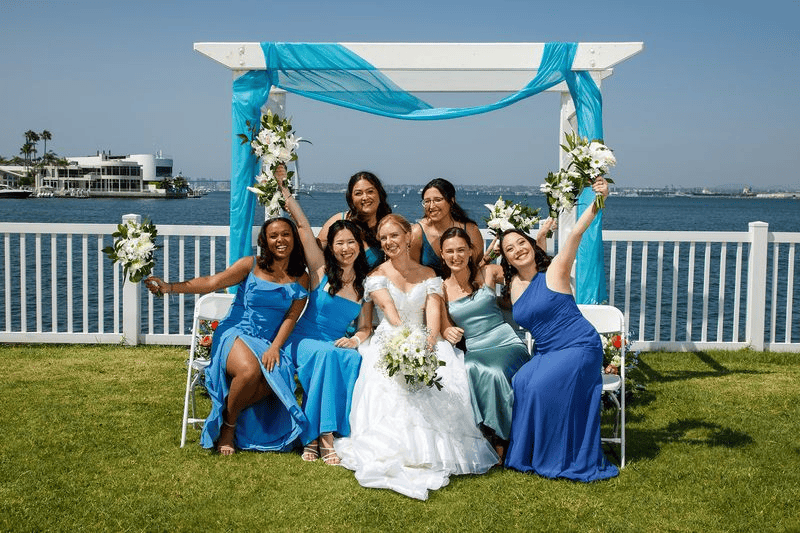 Bride with bridesmaids in blue dresses posing at an intimate wedding in San Diego.