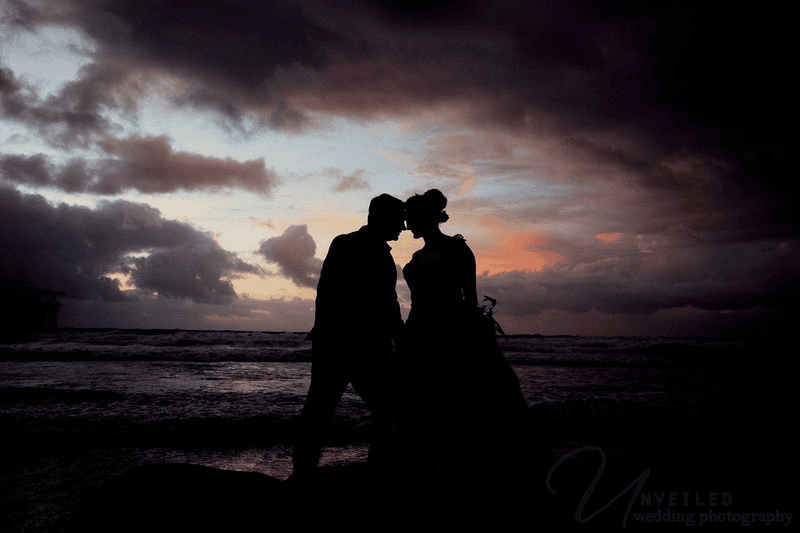 Silhouette of bride and groom touching foreheads for Sunset Cliffs elopement photos.
Option 2 (83 Characters)