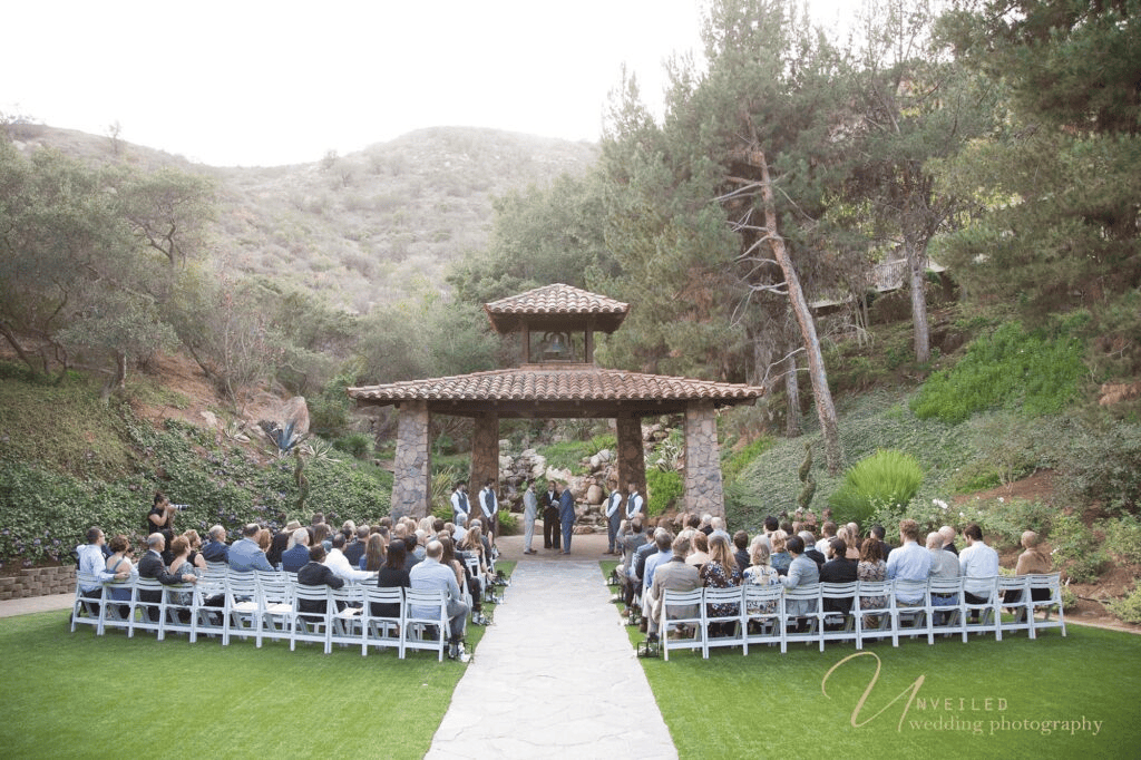 Outdoor wedding ceremony under gazebo by same-sex wedding photographer in San Diego.