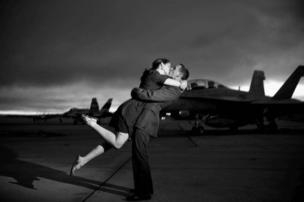 Black and white military kiss on airfield for an engagement session before your wedding.