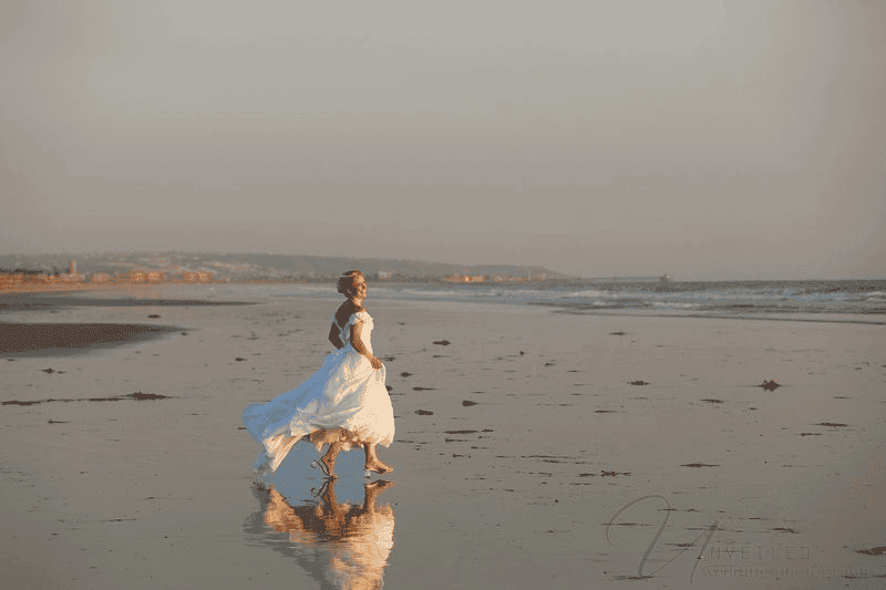 Bride running along sunset beach reflecting Wedding Photography Trends 2027.