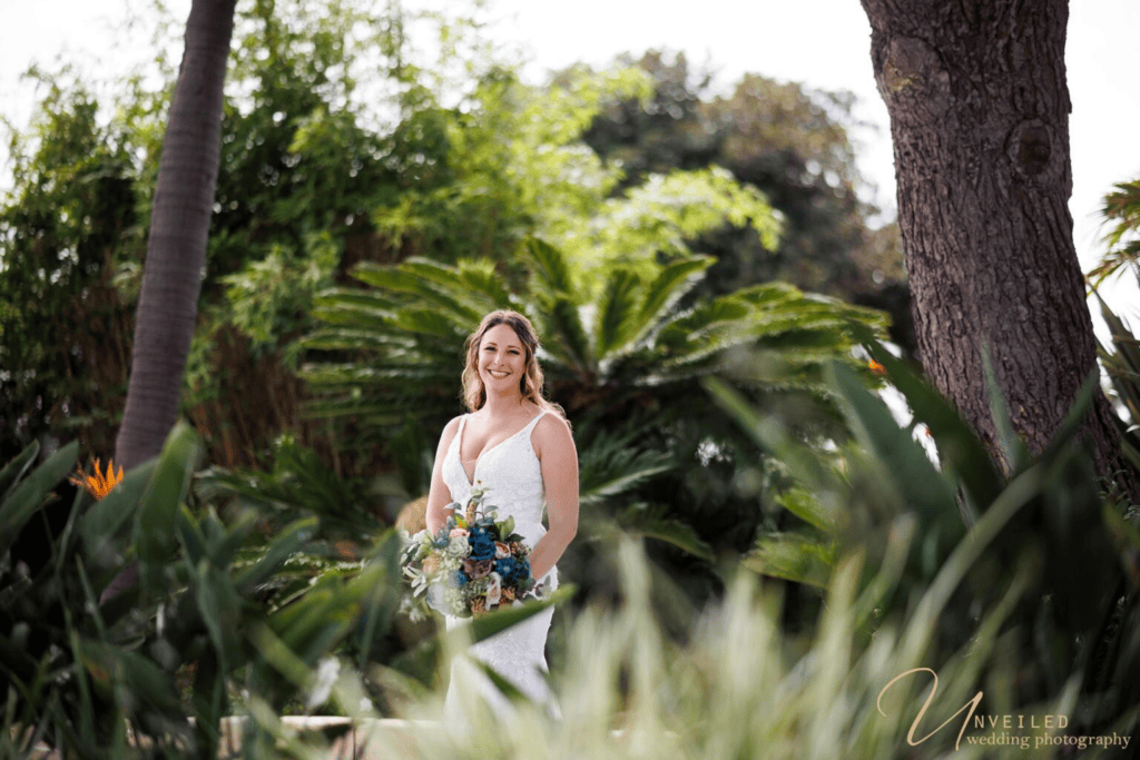 Smiling bride with floral bouquet outdoors for Wedding Photography Coverage.