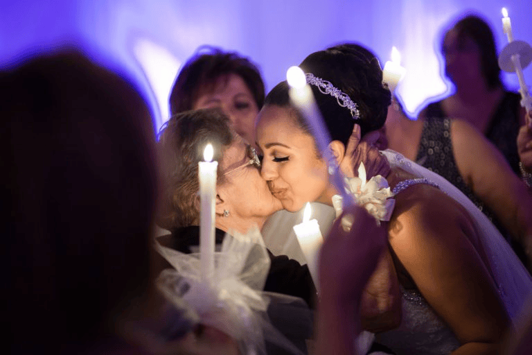 Bride kissing family member at candlelight ceremony for Wedding Photography Trends 2027.