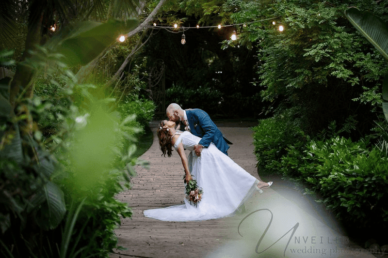 Groom dipping bride under string lights capturing Wedding Photography Trends 2027.