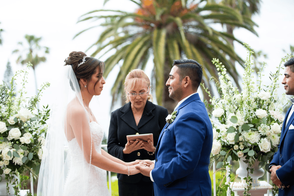 Bride and groom holding hands during altar vows in Wedding photography shots.
