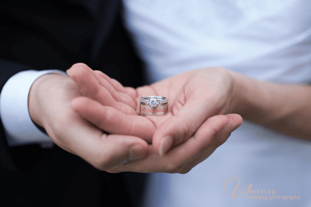 Close up of wedding rings in hands for fine art vs documentary wedding photography.