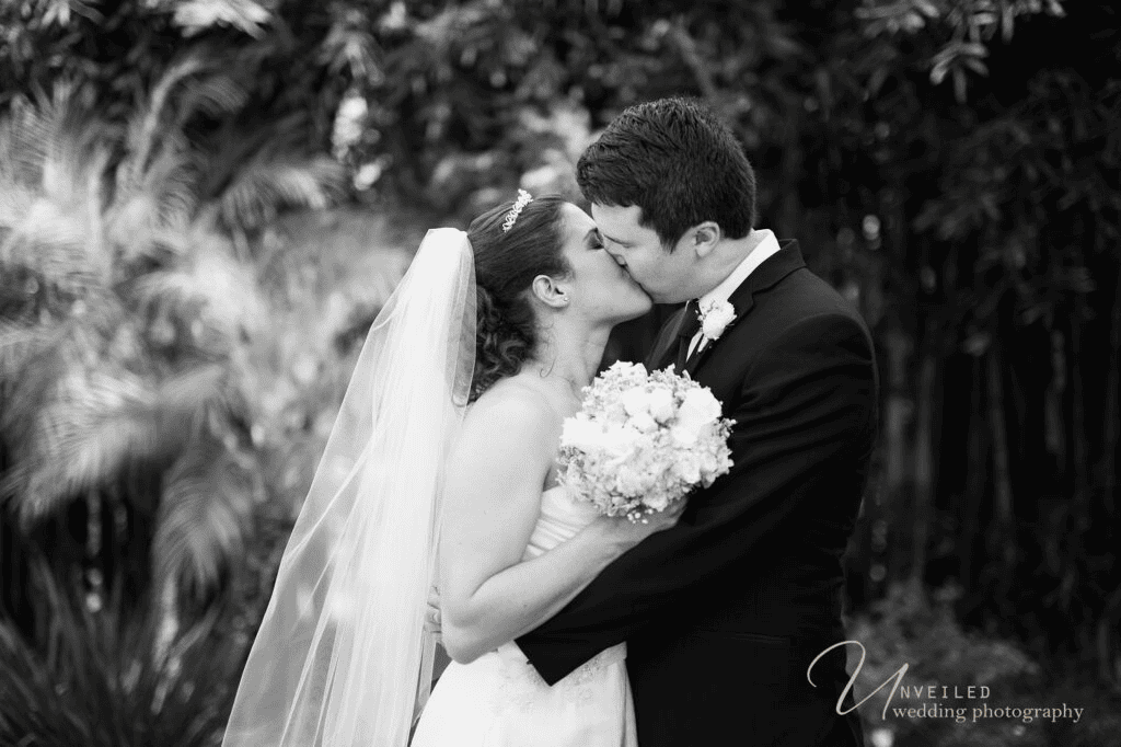 Black and white kissing couple portrait in fine art vs documentary wedding photography.
